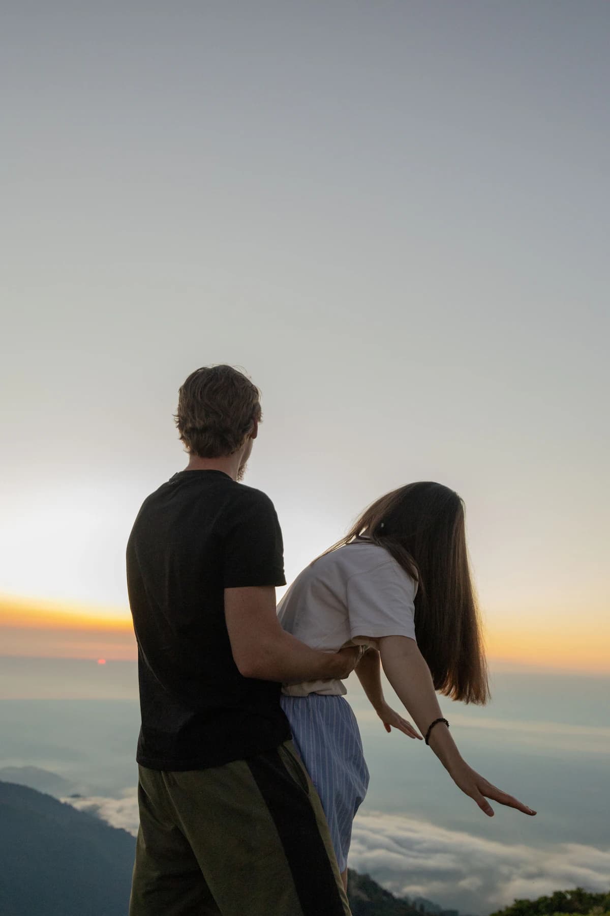 Un couple contemple le paysage au coucher du soleil